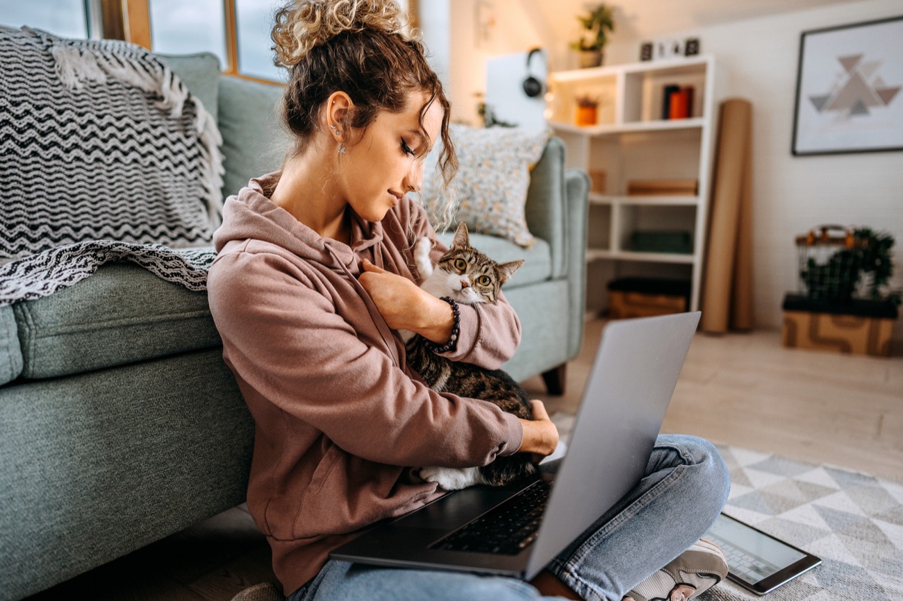 Una tutora con su gato consultando a Wagg desde la notebook